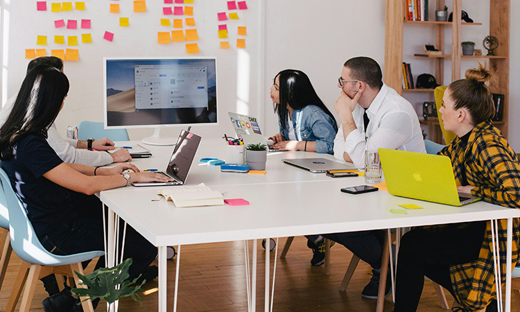 Image of people sitting around a table in a meeting room